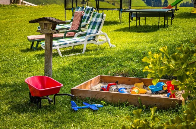 Erwachsene können sich sonnen und die Kinder spielen am Spielplatz
